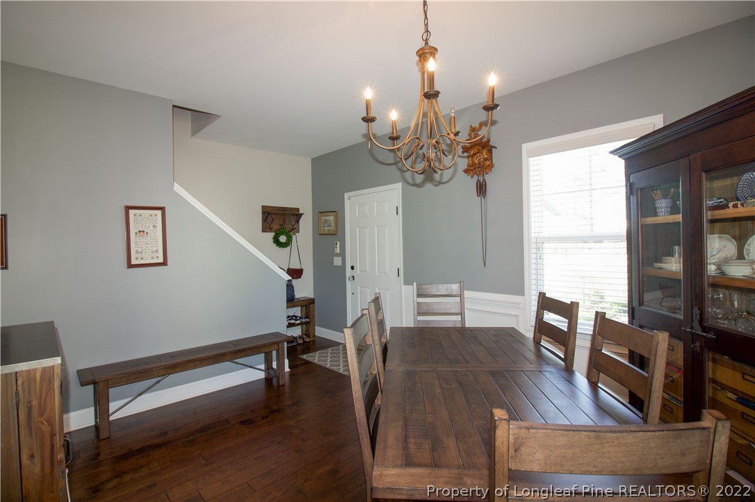 202 Sandy Springs Road Aberdeen, NC 28315 - Photo 12 of 44 a living room with furniture dining table wooden floor and a chandelier