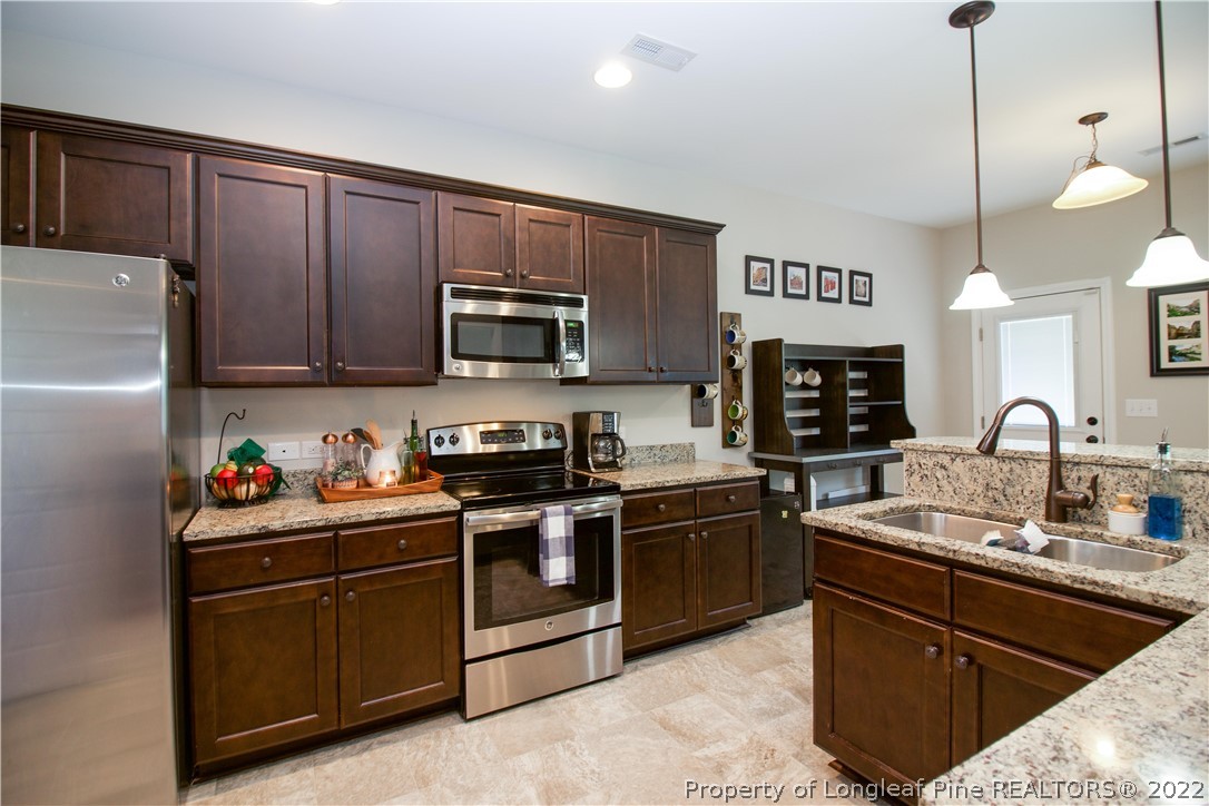 202 Sandy Springs Road Aberdeen, NC 28315 - Photo 15 of 44 a kitchen with stainless steel appliances granite countertop a sink stove and refrigerator