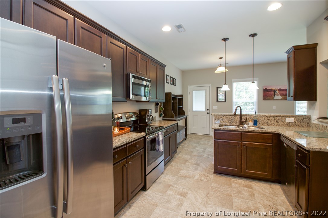 202 Sandy Springs Road Aberdeen, NC 28315 - Photo 16 of 44 a kitchen with stainless steel appliances granite countertop a refrigerator a stove a sink and a microwave