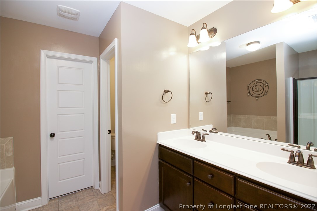 202 Sandy Springs Road Aberdeen, NC 28315 - Photo 21 of 44 a bathroom with a double vanity sink a mirror and a shower