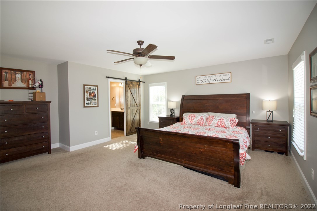 202 Sandy Springs Road Aberdeen, NC 28315 - Photo 23 of 44 a spacious bedroom with a bed and a chandelier