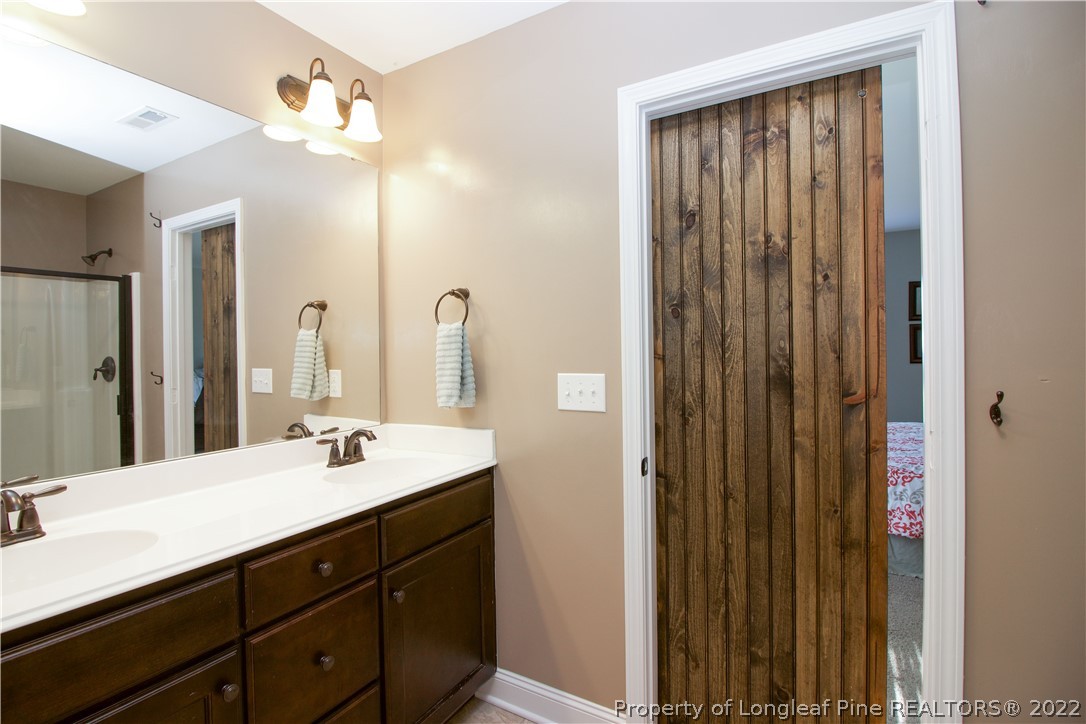 202 Sandy Springs Road Aberdeen, NC 28315 - Photo 25 of 44 a bathroom with a double vanity sink and a mirror