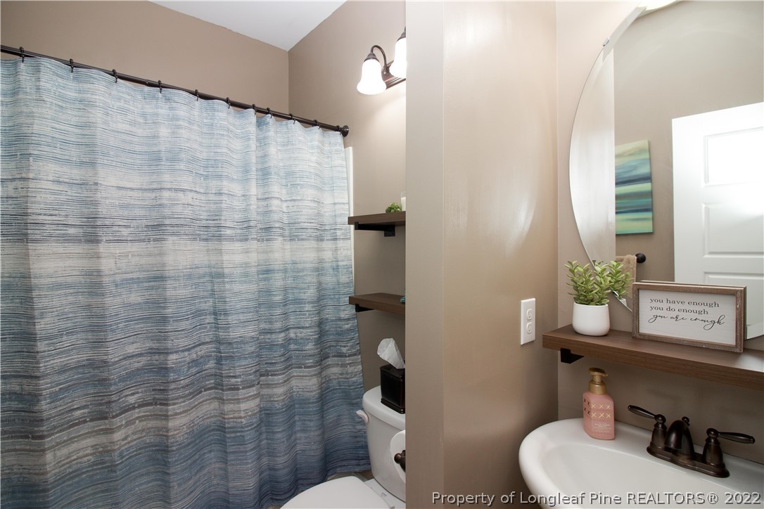 202 Sandy Springs Road Aberdeen, NC 28315 - Photo 36 of 44 a bathroom with a toilet a sink and a mirror