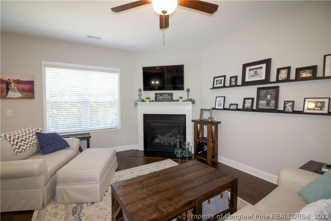 202 Sandy Springs Road Aberdeen, NC 28315 - Photo 5 of 44 a living room with furniture a flat screen tv and a fireplace