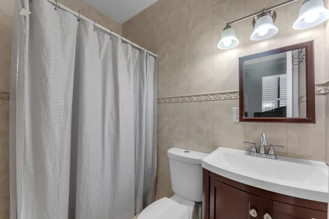 a bathroom with a sink vanity mirror and toilet