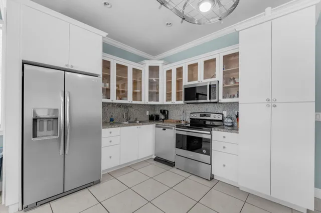 a kitchen with stainless steel appliances granite countertop a refrigerator and a stove top oven