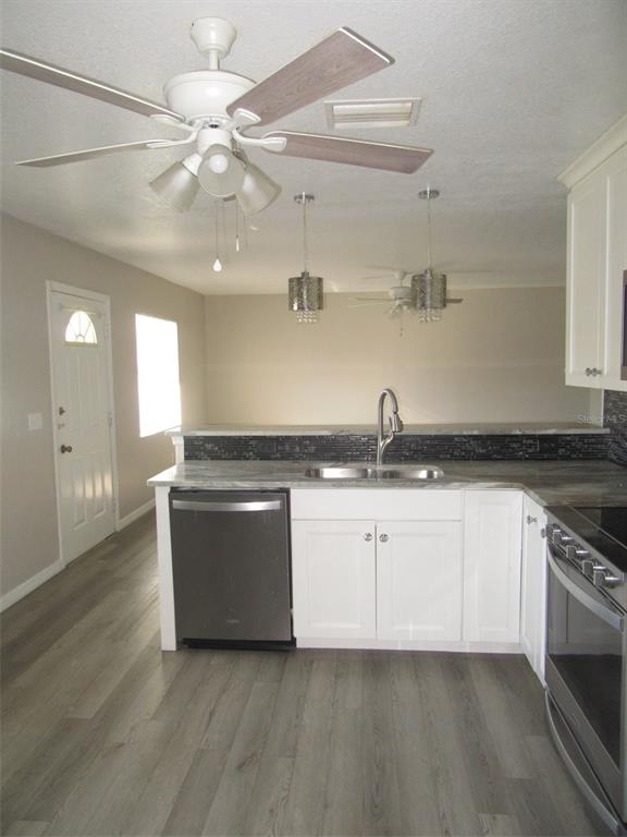 1090 Nomad Road Punta Gorda, FL 33983 - Photo 7 of 16 a kitchen with stainless steel appliances granite countertop a sink and stove