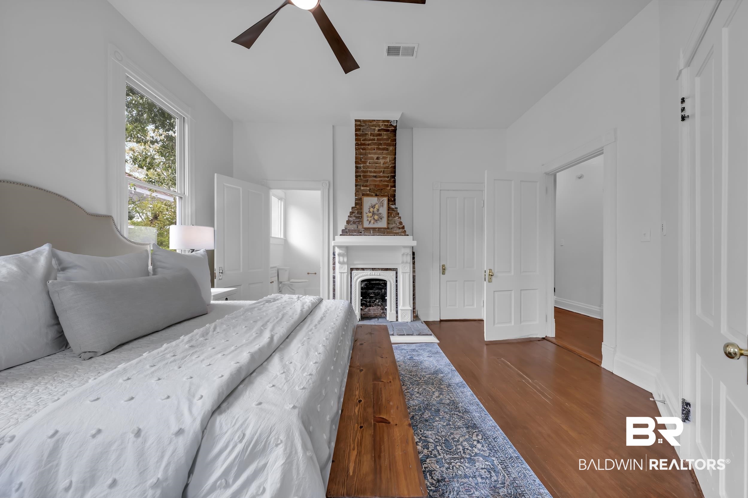 1662 Government Street Mobile, AL 36604 - Photo 21 of 33 Bedroom with dark wood-type flooring, a fireplace, ceiling fan, and a closet