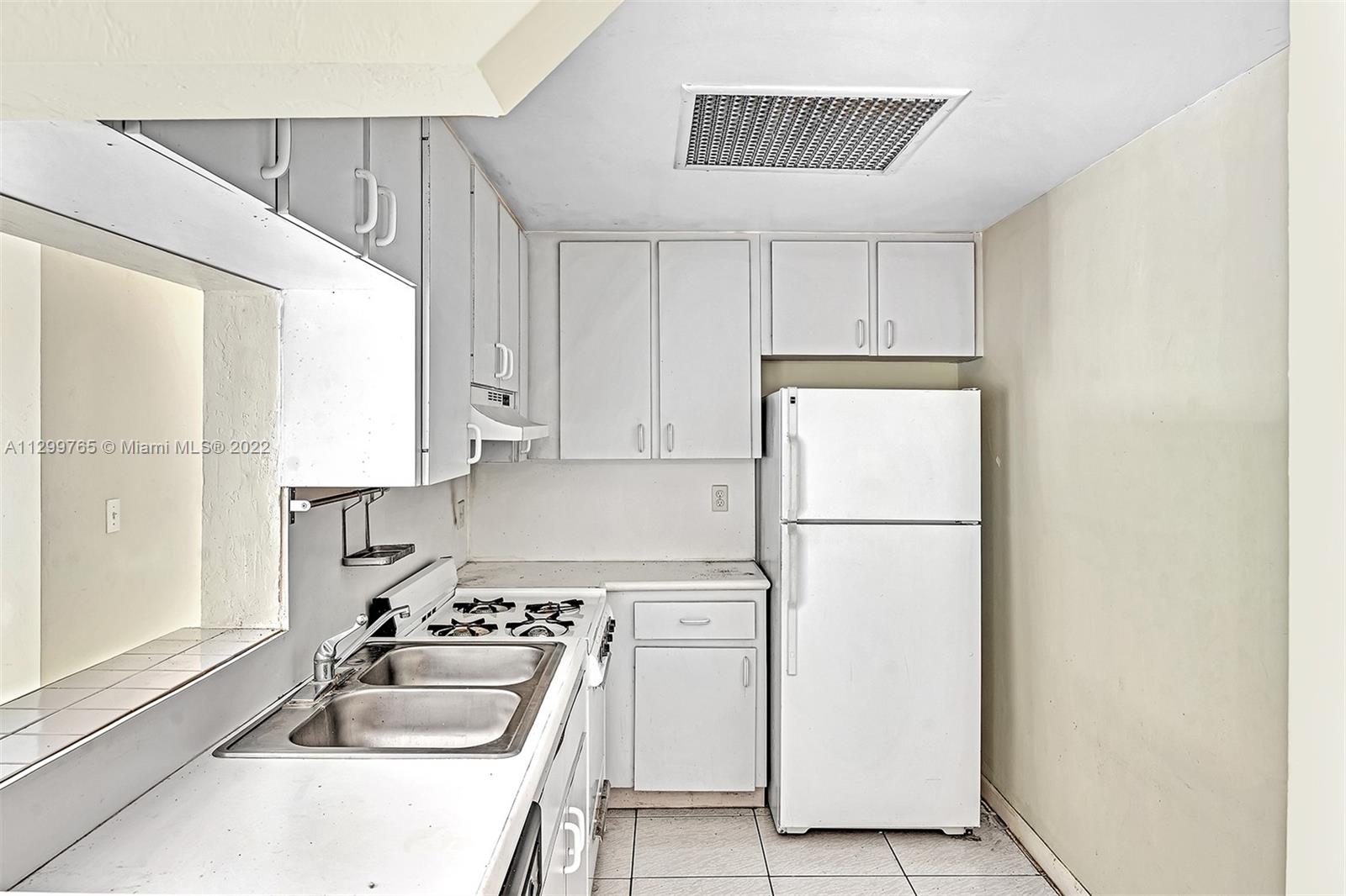 2201 Brickell Avenue, Unit 89 Miami, FL 33129 - Photo 11 of 56 a kitchen with a refrigerator a sink and cabinets