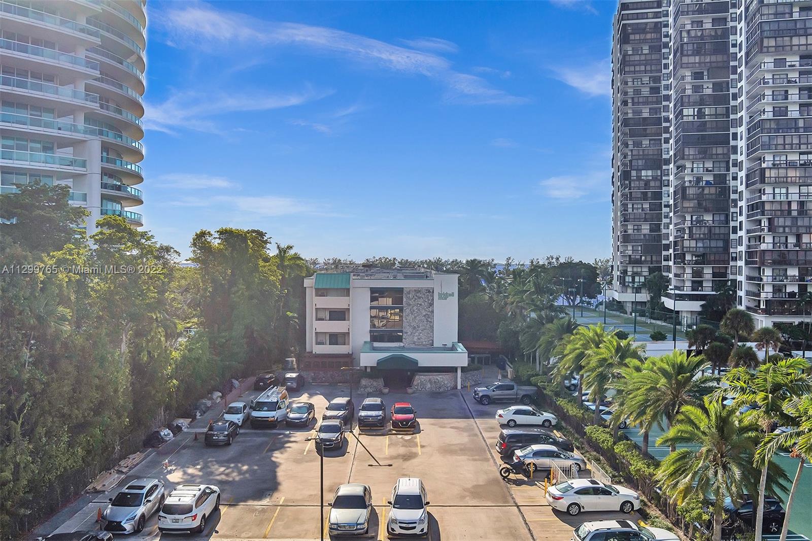 2201 Brickell Avenue, Unit 89 Miami, FL 33129 - Photo 52 of 56 a view of a patio with couches and table and chairs with wooden floor and fence