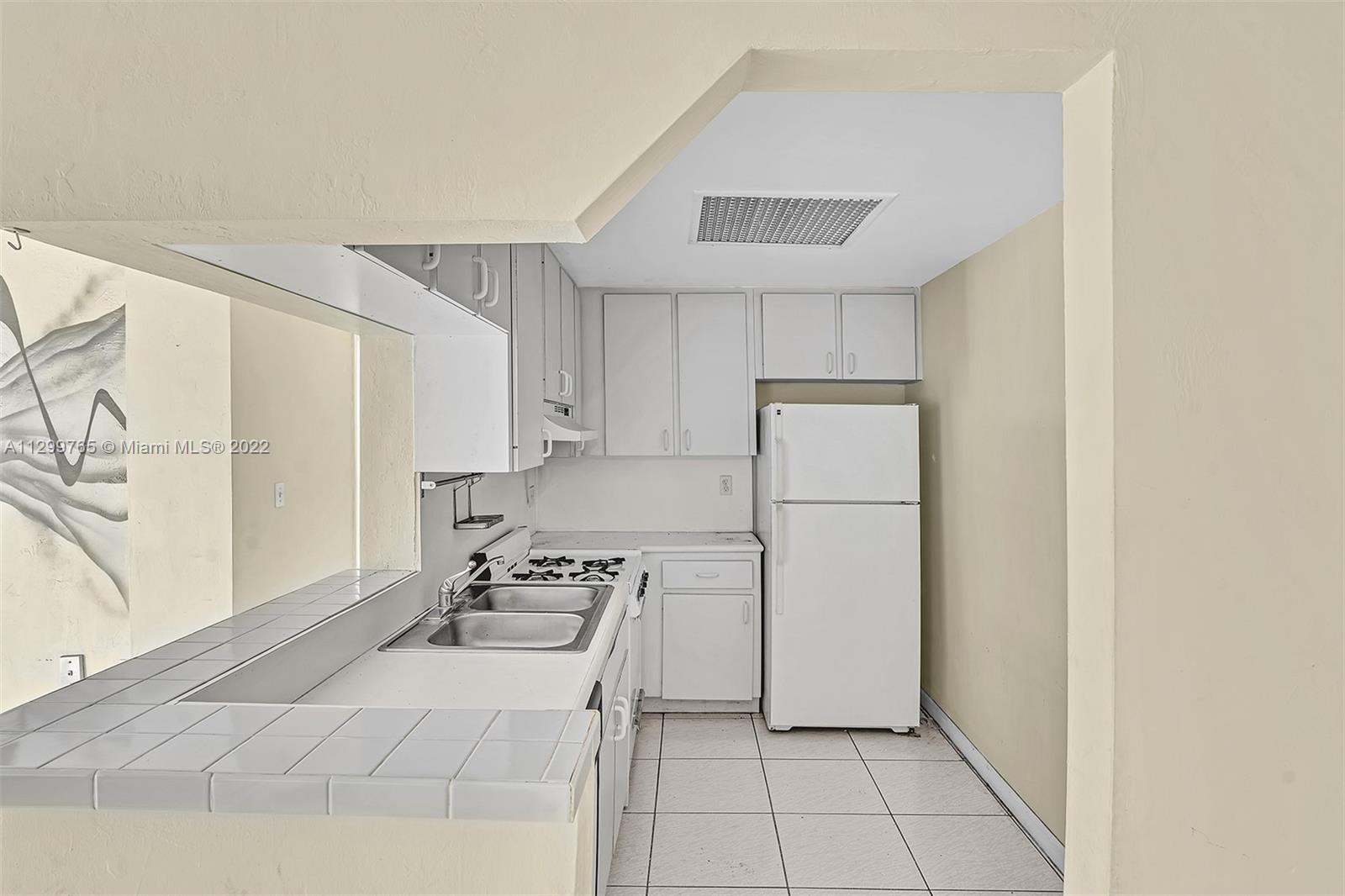 2201 Brickell Avenue, Unit 89 Miami, FL 33129 - Photo 6 of 56 a kitchen with a refrigerator a stove top oven and cabinets