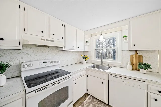 a kitchen with white cabinets and white appliances