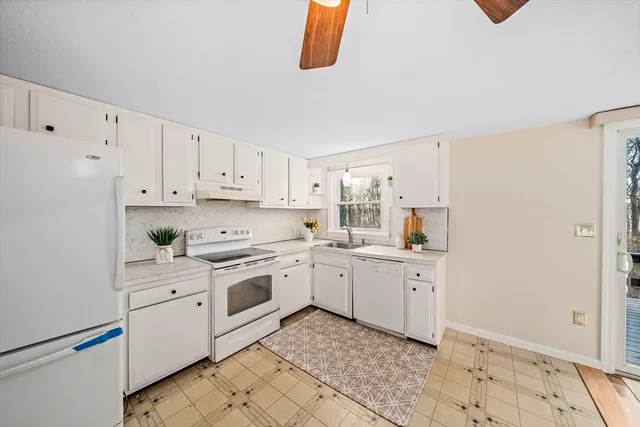 a kitchen with white cabinets and white appliances