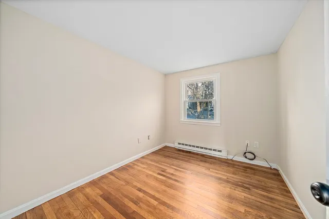 a view of a room with wooden floor and white walls