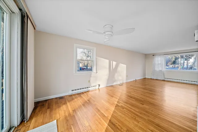 a view of empty room with window and wooden floor
