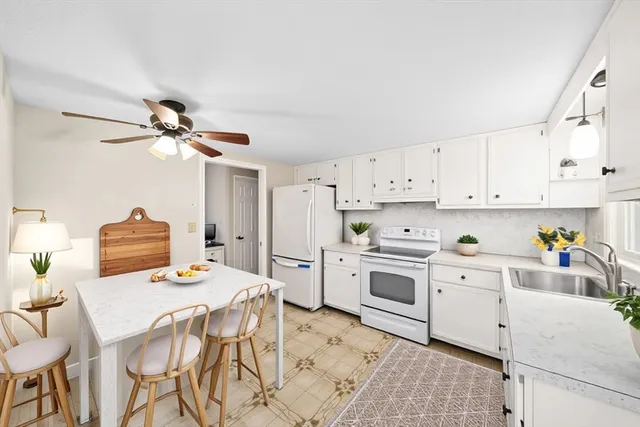 a kitchen with stainless steel appliances white cabinets and a refrigerator