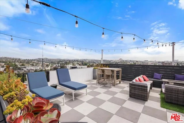 a roof deck with table and chairs