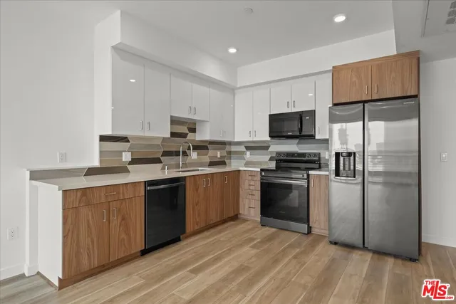 a kitchen with stainless steel appliances granite countertop a refrigerator stove a sink and a microwave