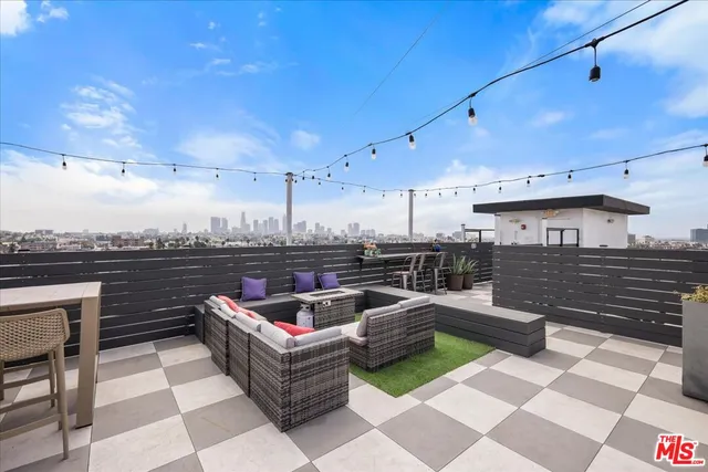 a roof deck with couches and potted plants