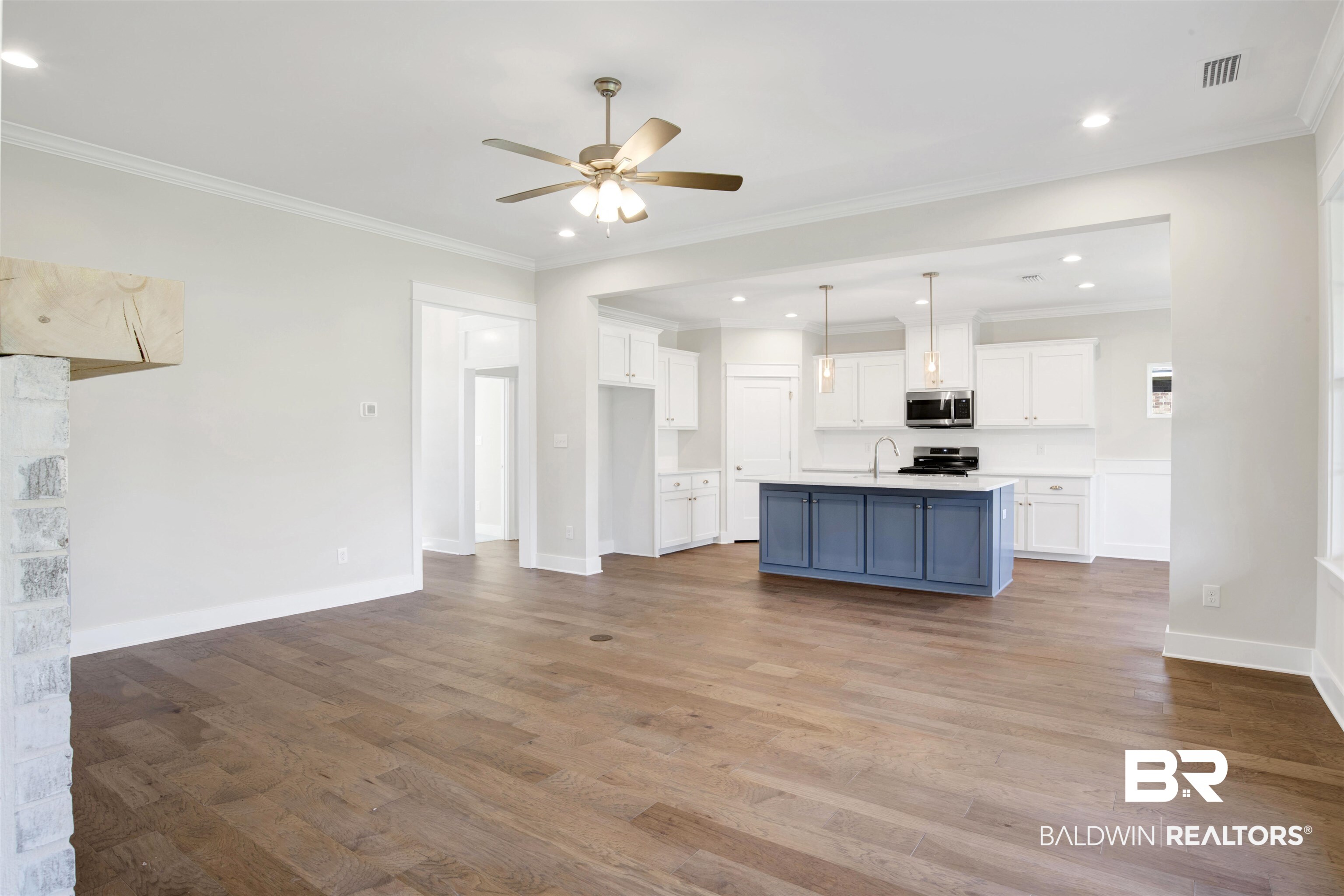 9687 Widgeon Court Daphne, AL 36526 - Photo 6 of 40 Kitchen featuring a kitchen island with sink, white cabinets, stainless steel appliances, and light hardwood / wood-style floors