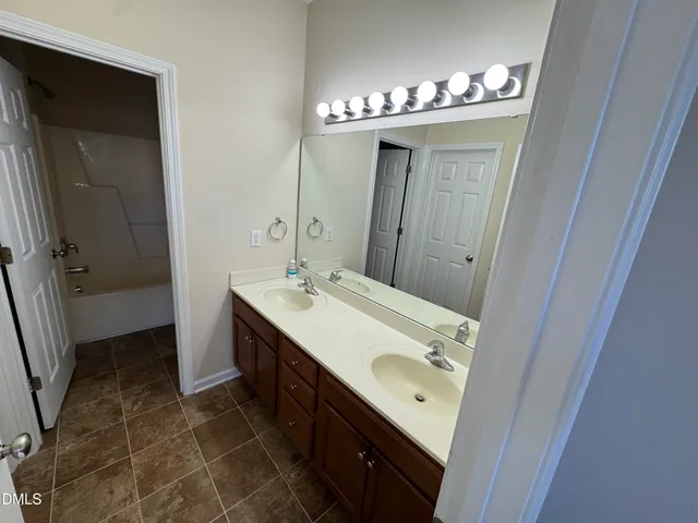 a bathroom with a double vanity sink and mirror