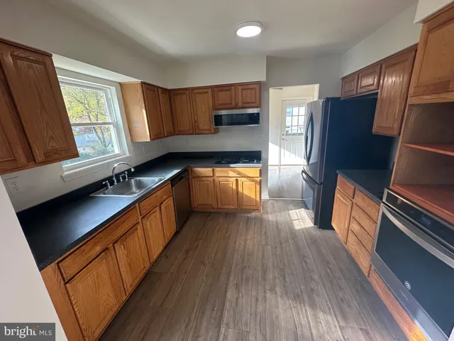 a kitchen with stainless steel appliances granite countertop a sink a stove a microwave and cabinets