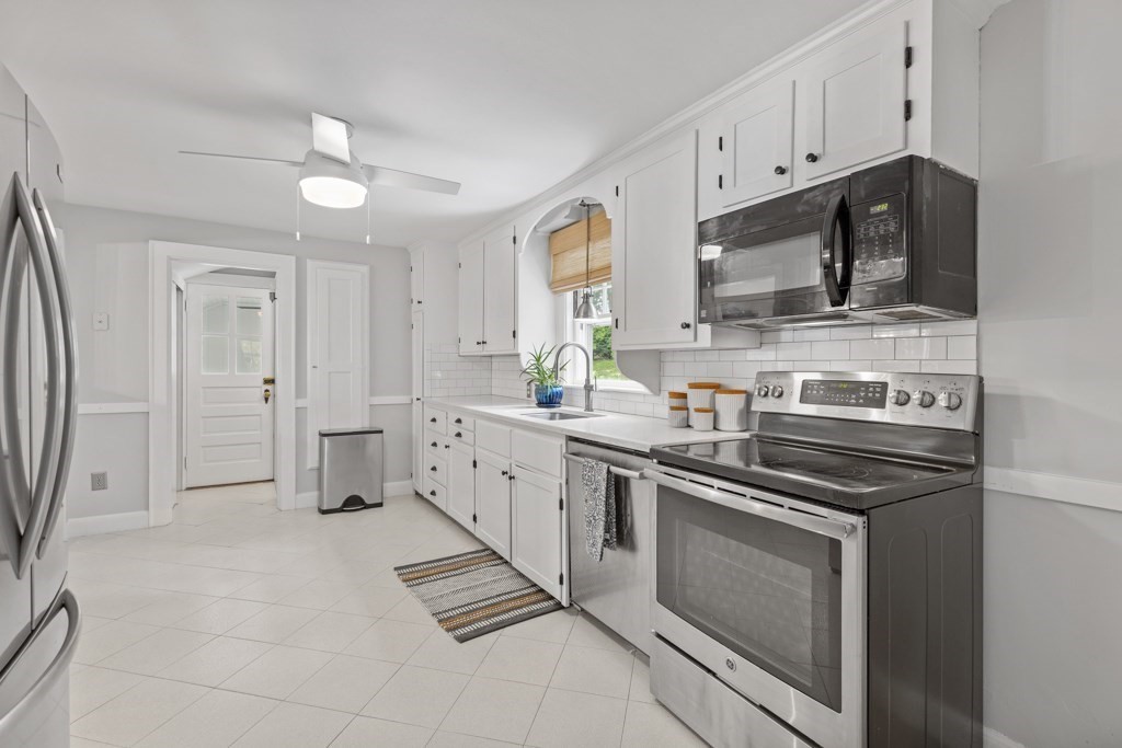 24 Pine Hill Circle Wakefield, MA 01880 - Photo 7 of 34 a kitchen with stainless steel appliances a stove sink and cabinets