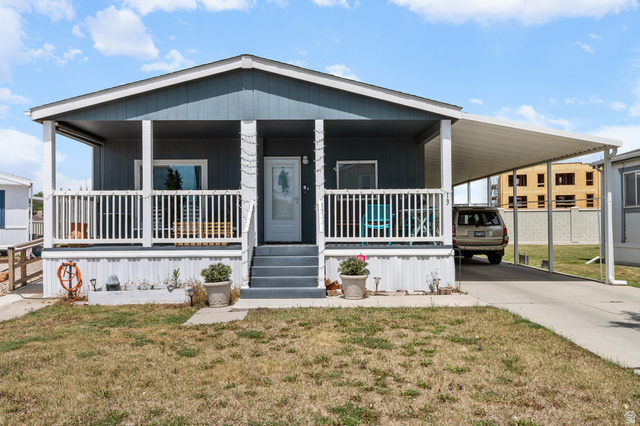 150 West 7500th South, Unit 13 Midvale, UT 84047 - Photo 27 of 32 Single-story residence featuring a covered front porch with white railing, a carport, and a light blue exterior siding
