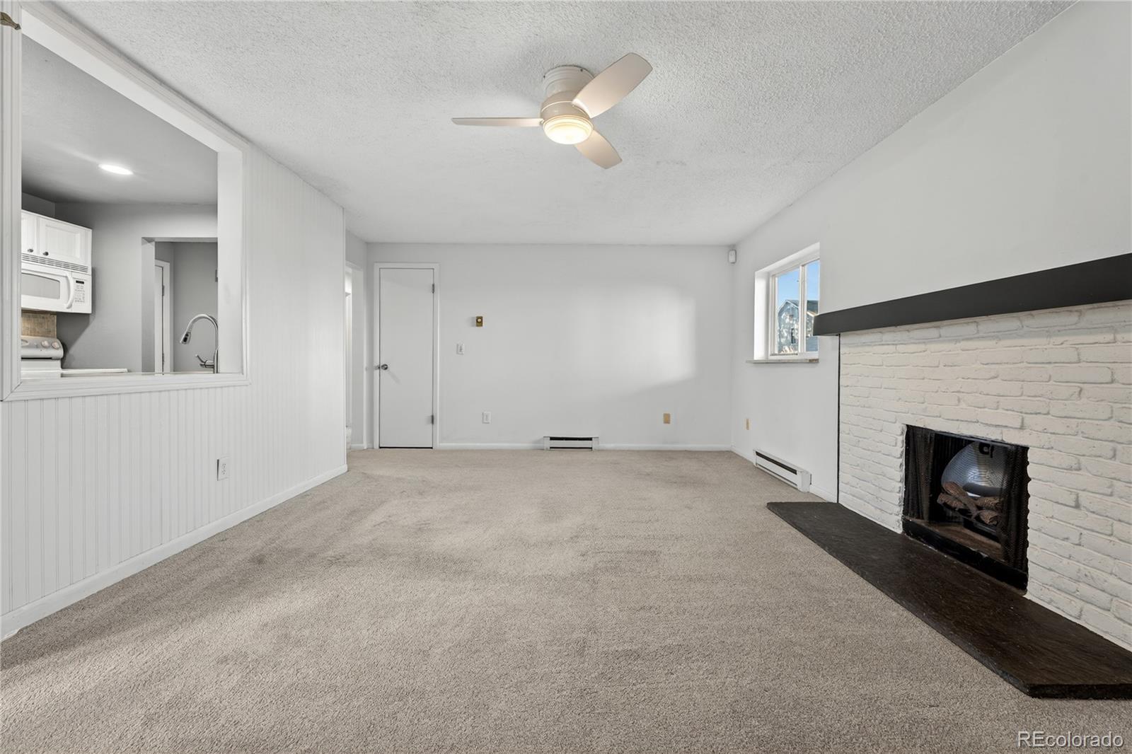 4066 South Atchison Way, Unit 101 Aurora, CO 80014 - Photo 14 of 36 an empty room with fireplace and fan
