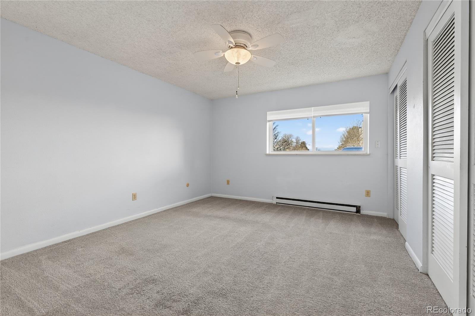 4066 South Atchison Way, Unit 101 Aurora, CO 80014 - Photo 18 of 36 an empty room with a ceiling fan and a window