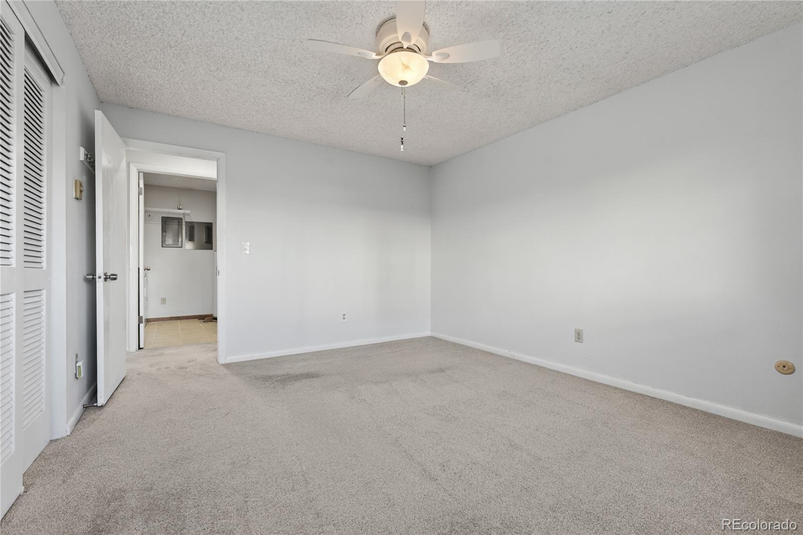 4066 South Atchison Way, Unit 101 Aurora, CO 80014 - Photo 19 of 36 an empty room with a chandelier fan and a window