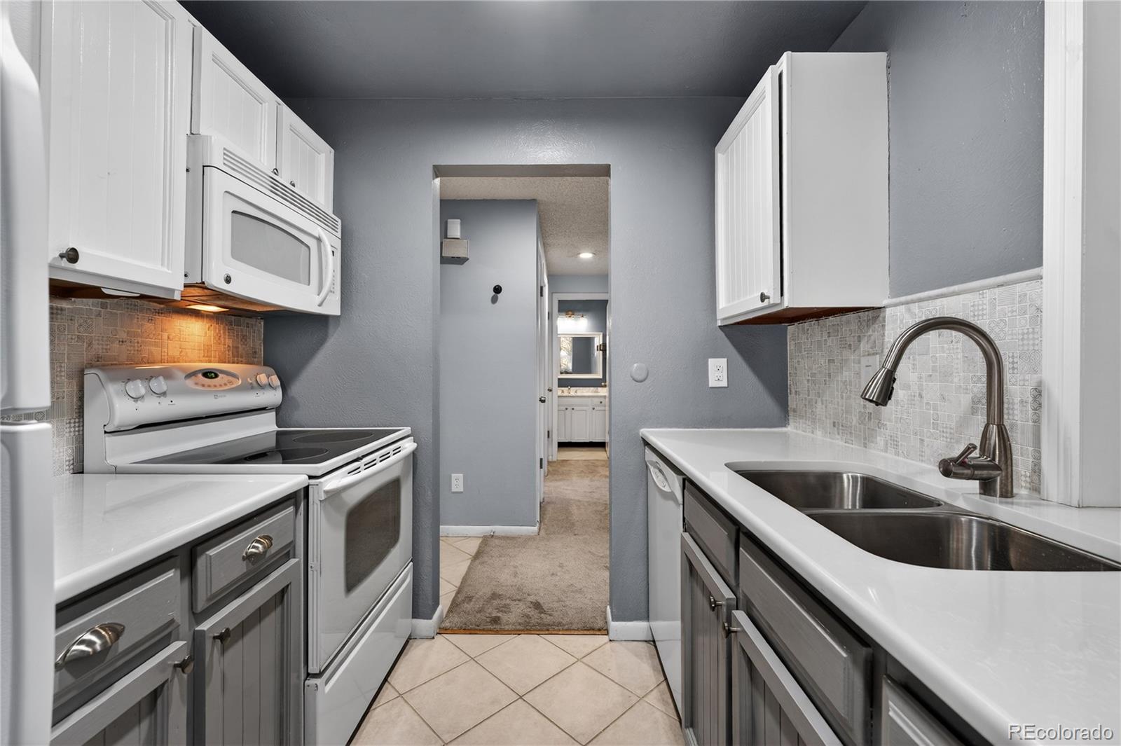 4066 South Atchison Way, Unit 101 Aurora, CO 80014 - Photo 7 of 36 a kitchen with stainless steel appliances granite countertop a sink stove and refrigerator