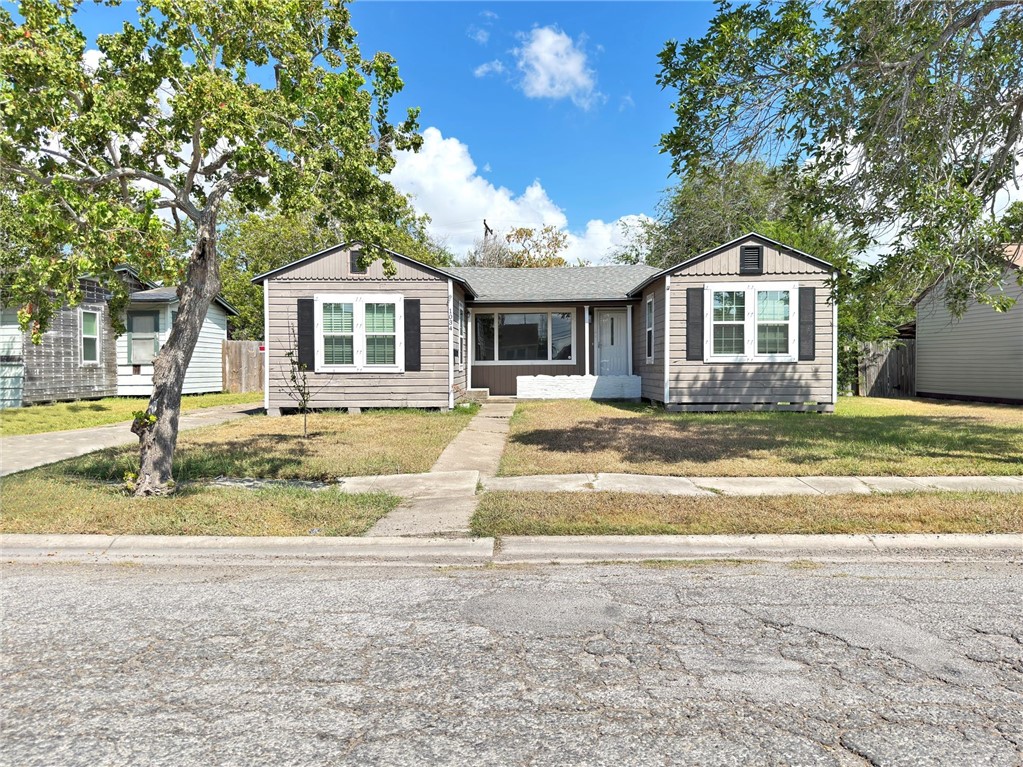 a front view of a house with a yard and trees