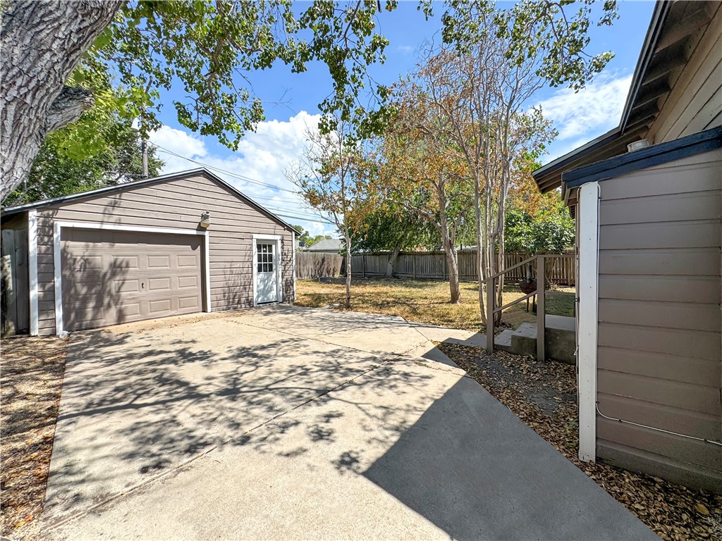 1034 Mc Clendon Street Corpus Christi, TX 78404 - Photo 17 of 19 a backyard of a house with large trees and outdoor seating