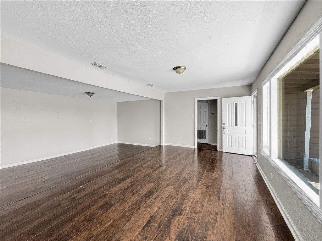 1034 Mc Clendon Street Corpus Christi, TX 78404 - Photo 4 of 19 a view of an empty room with wooden floor and a window