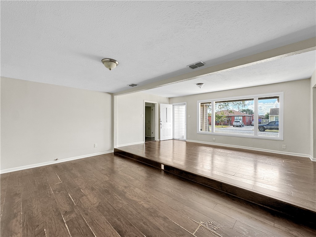 1034 Mc Clendon Street Corpus Christi, TX 78404 - Photo 5 of 19 an empty room with wooden floor and windows