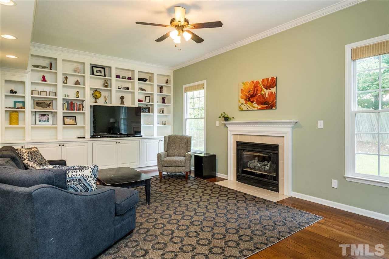 3316 Stone Castle Court Raleigh, NC 27613 - Photo 12 of 25 a living room with furniture a flat screen tv and a fireplace