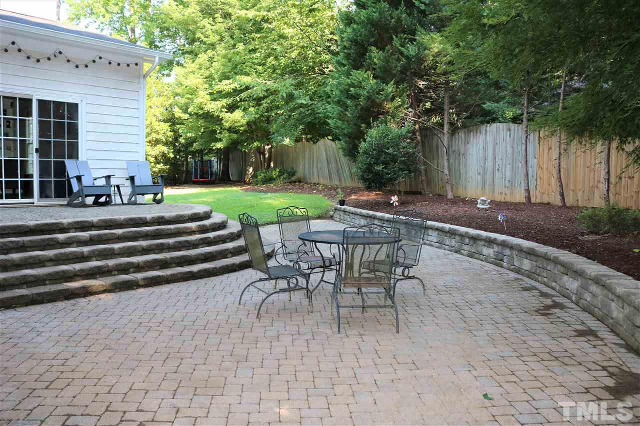 3316 Stone Castle Court Raleigh, NC 27613 - Photo 24 of 25 a view of a patio with table and chairs with wooden fence and plants