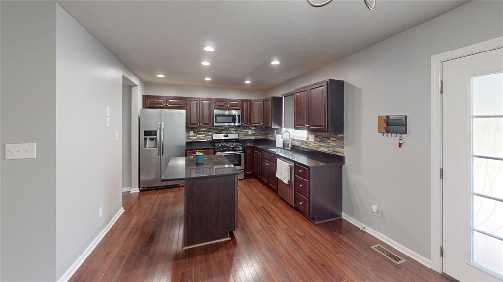 138 Watson Drive Warrendale, PA 15086 - Photo 5 of 24 a kitchen with stainless steel appliances granite countertop a refrigerator a stove top oven a sink and dishwasher with wooden floor