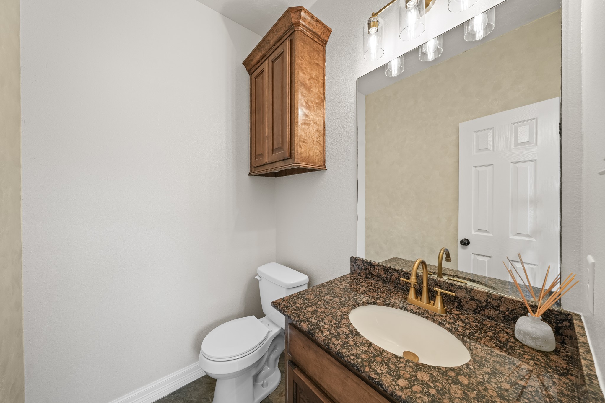 6101 Fox Ridge Drive Angleton, TX 77515 - Photo 9 of 30 a bathroom with a granite countertop sink a toilet and a mirror