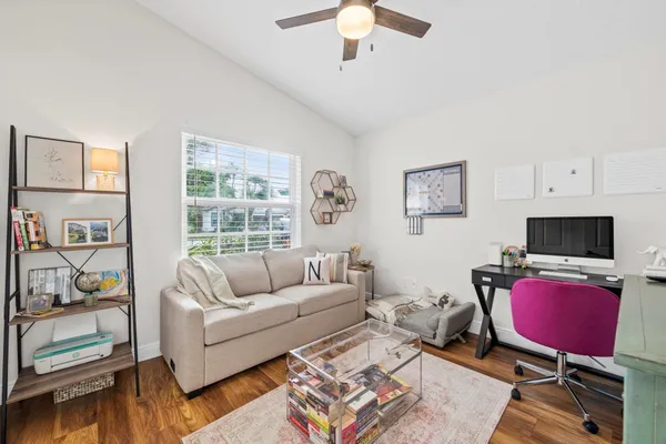 a living room with furniture a flat screen tv and a window