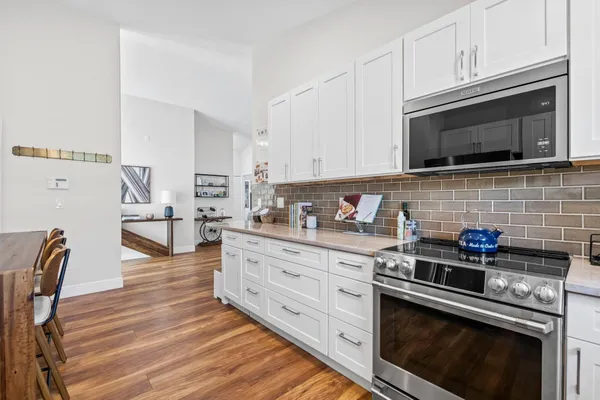 a kitchen with stainless steel appliances a stove microwave and cabinets