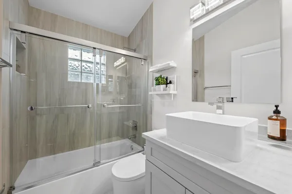 a bathroom with a sink a toilet and shower