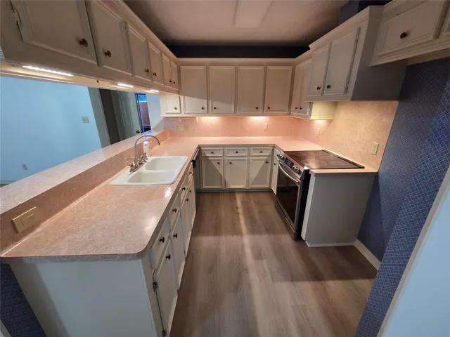 a kitchen with stainless steel appliances granite countertop a sink stove and cabinets