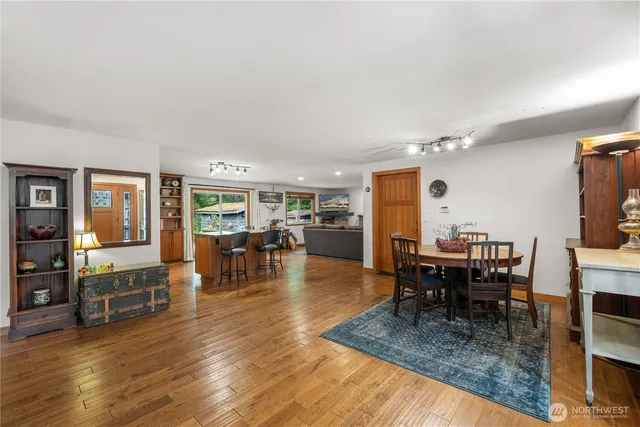 a dining area with furniture window and wooden floor