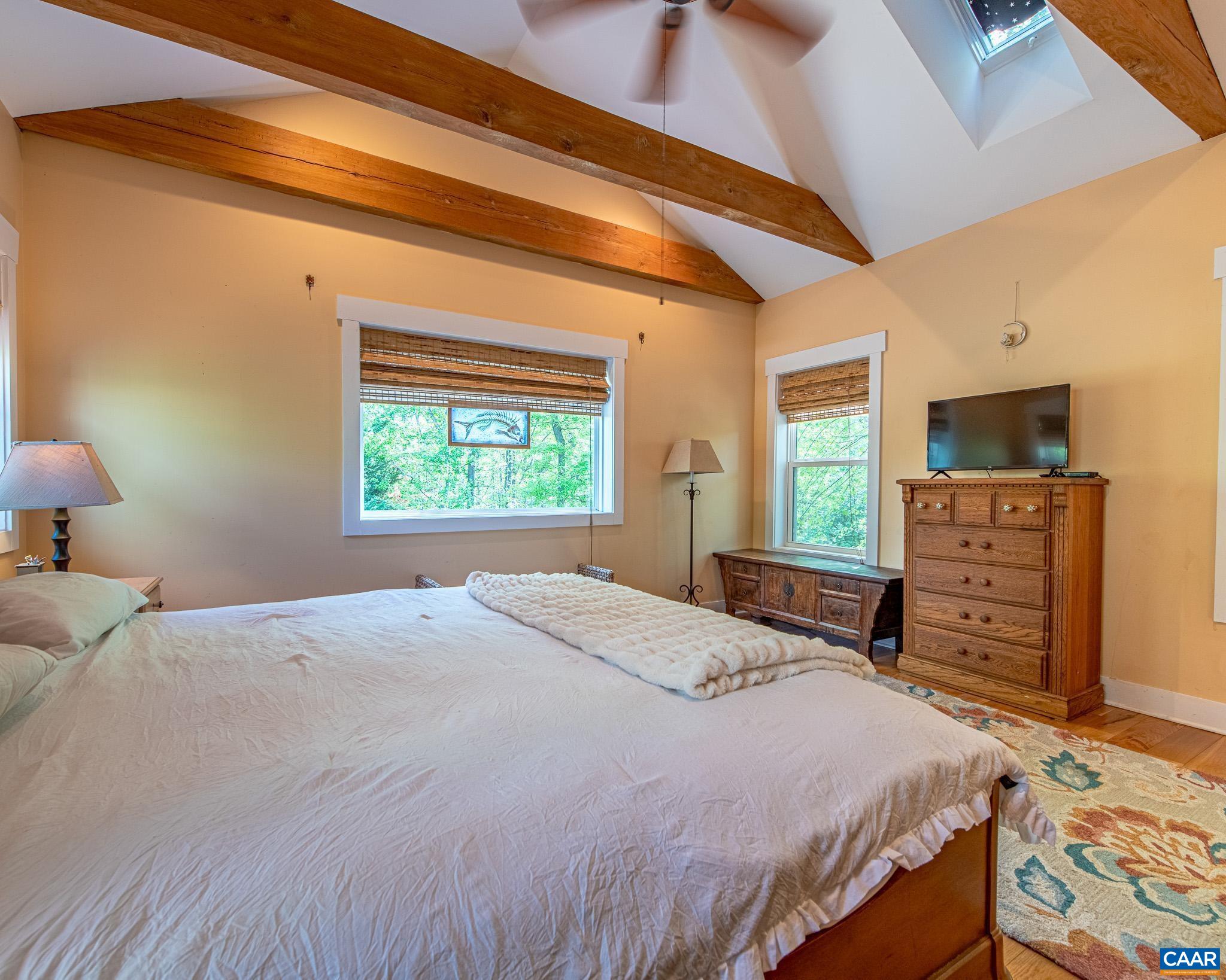 1671 Dudley Mountain Road Charlottesville, VA 22903 - Photo 18 of 60 a bedroom with a bed and a flat screen tv