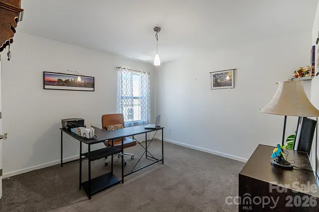 a view of a workspace with furniture and a window