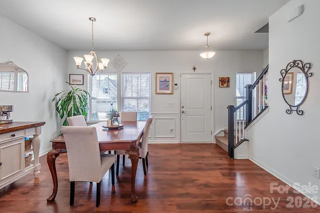 a view of a dining room with furniture a chandelier and wooden floor