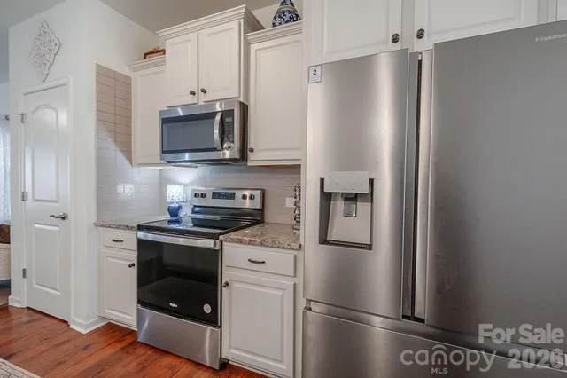 a kitchen with stainless steel appliances a refrigerator stove and microwave