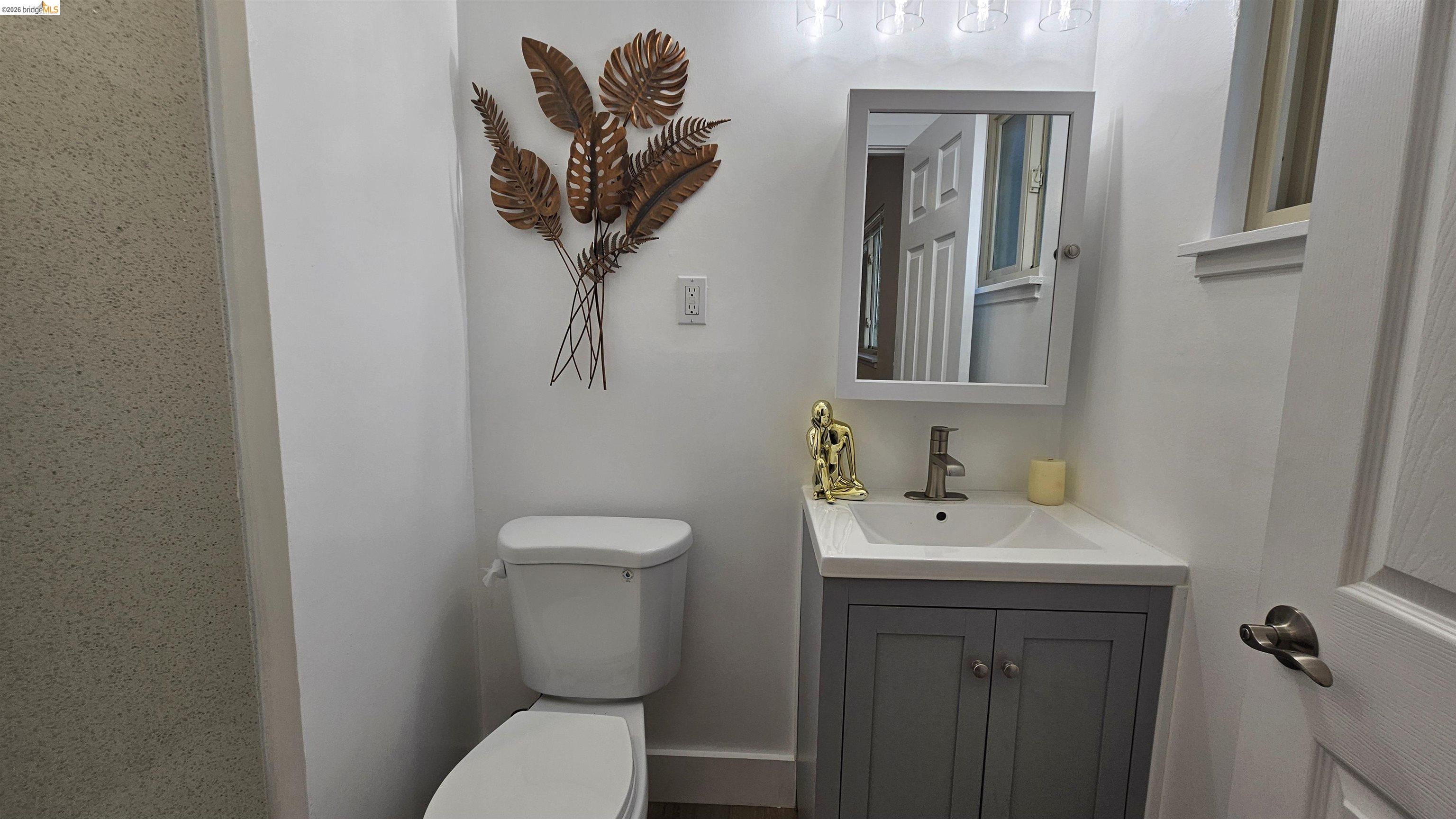 95 West Leland Road Pittsburg, CA 94565 - Photo 14 of 25 a bathroom with a toilet a sink and mirror